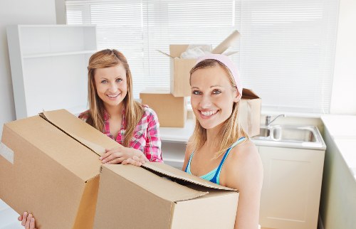 Professional movers handling apartment removals in a Canary Wharf riverside development